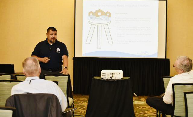 A representative of FEMA stands in front of a presentation in a meeting room at the 2019 Texas REALTORS® Conference in Fort Worth.
