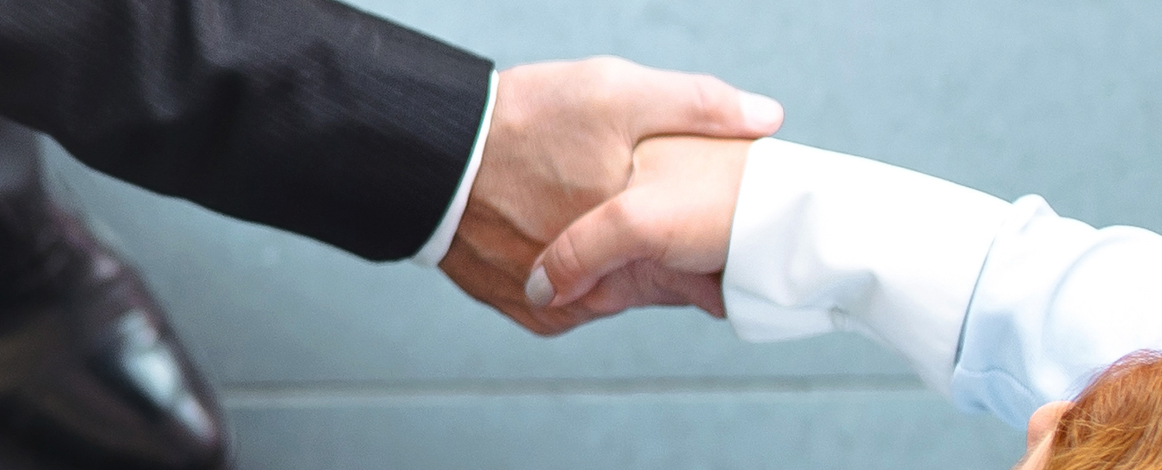 Two people shaking hands with only arms shown
