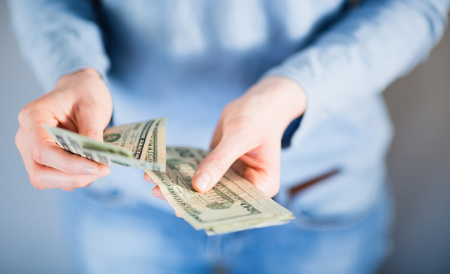 woman's hands counting US bills