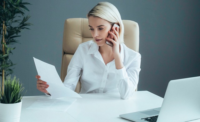 businesswoman sitting at desk on phone