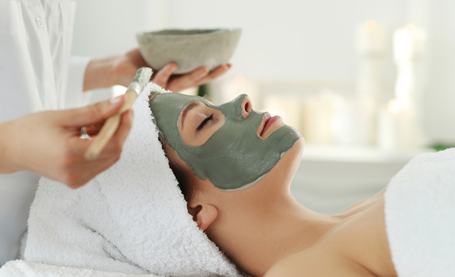 woman getting face mask at spa