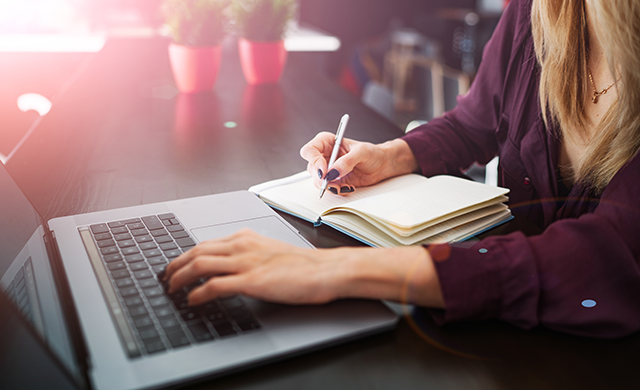 Woman taking notes during an online meeting